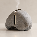 Natural Stone Texture – close-up of gold incense slot detail on porous grey stone surface, bring the serenity of nature indoors